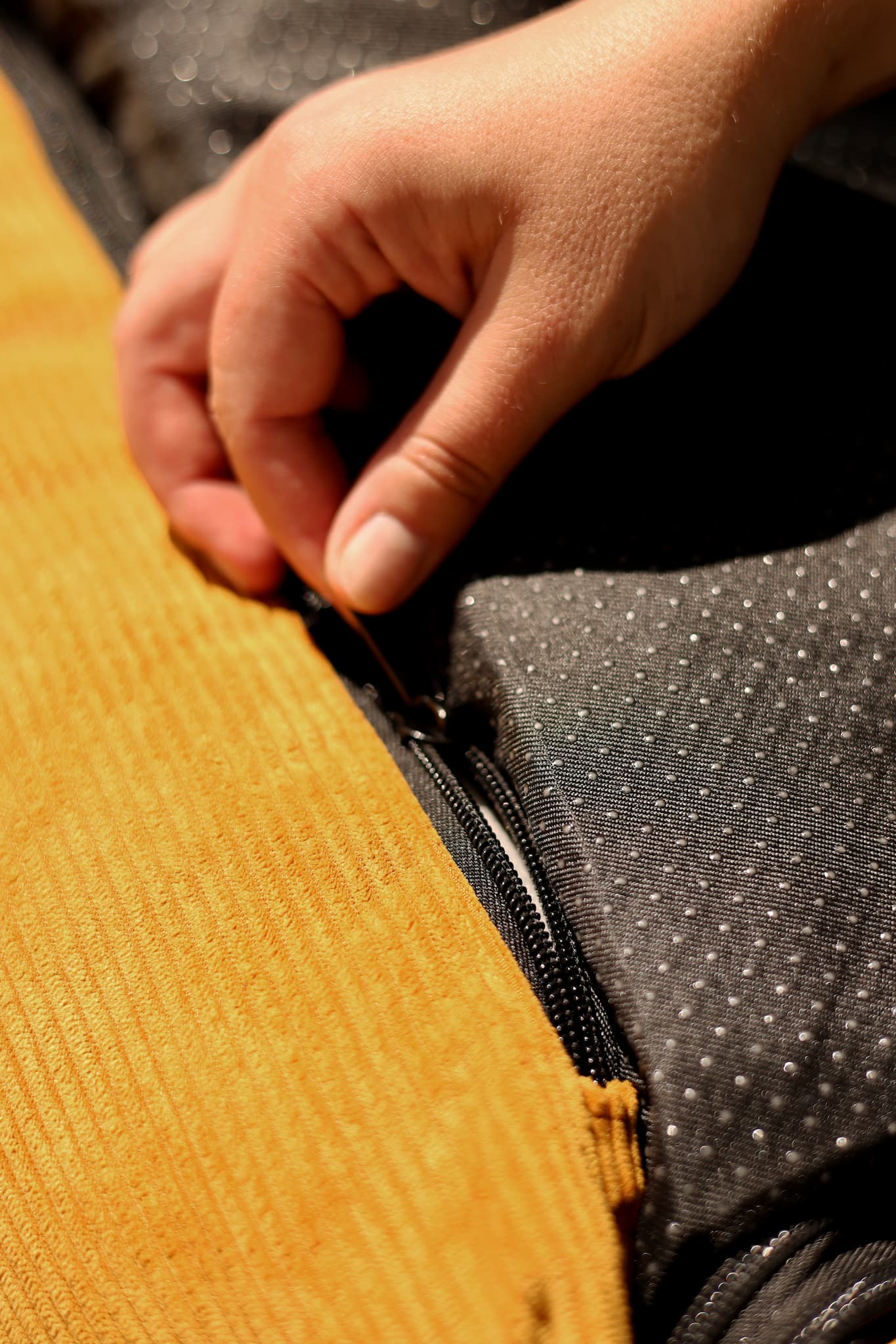 Close-up of dual-zip removable cover being unzipped for washing